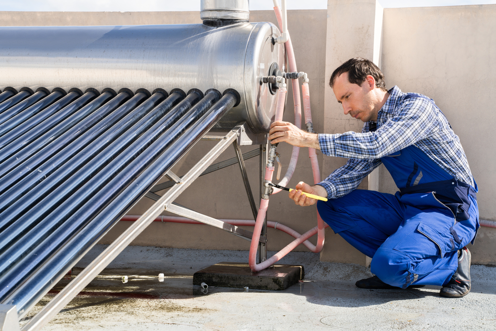 Male plumber repairing solar system