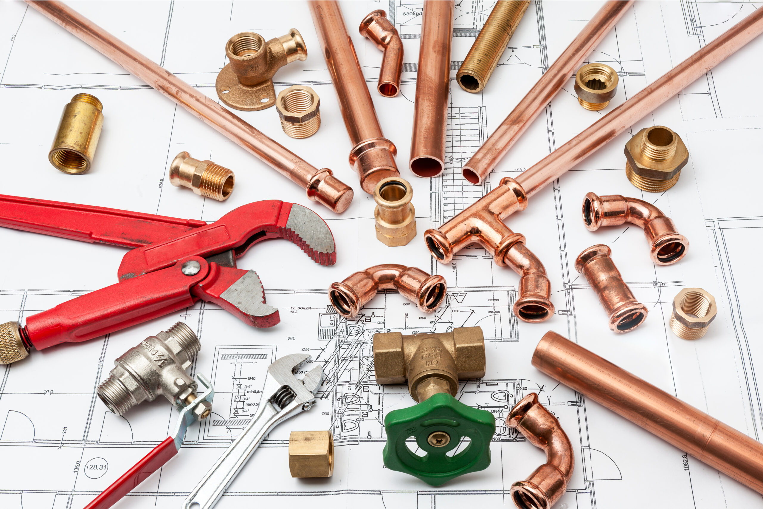 Plumbing tools and pipes arranged on house plans
