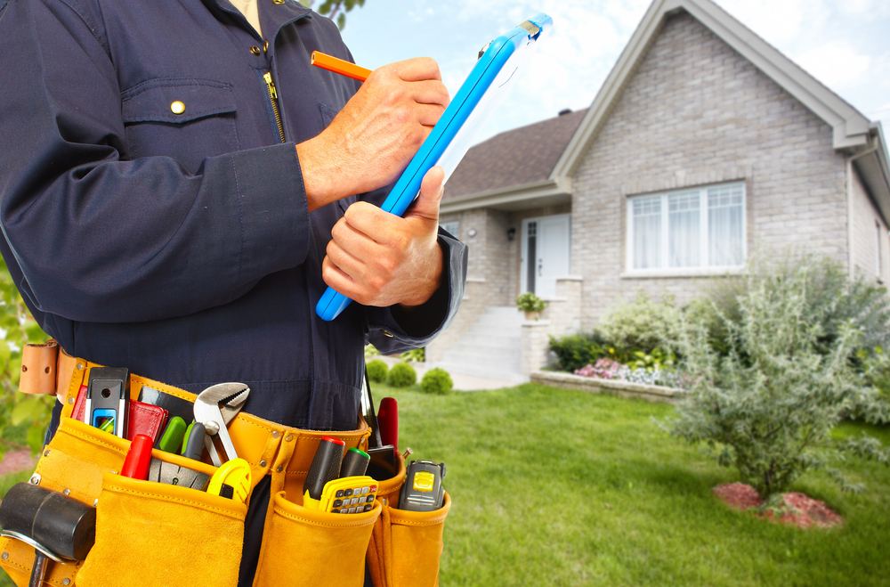 Residential plumber looking at a checklist in front of a family home